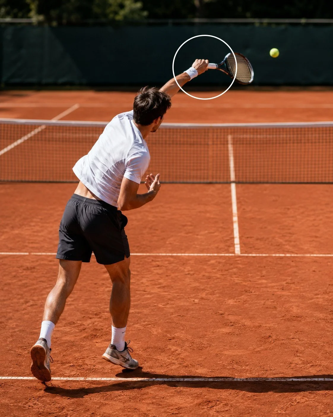 Rechtshändiger Tennisspieler bei der Pronation nach dem Aufschlag auf einem Sandplatz